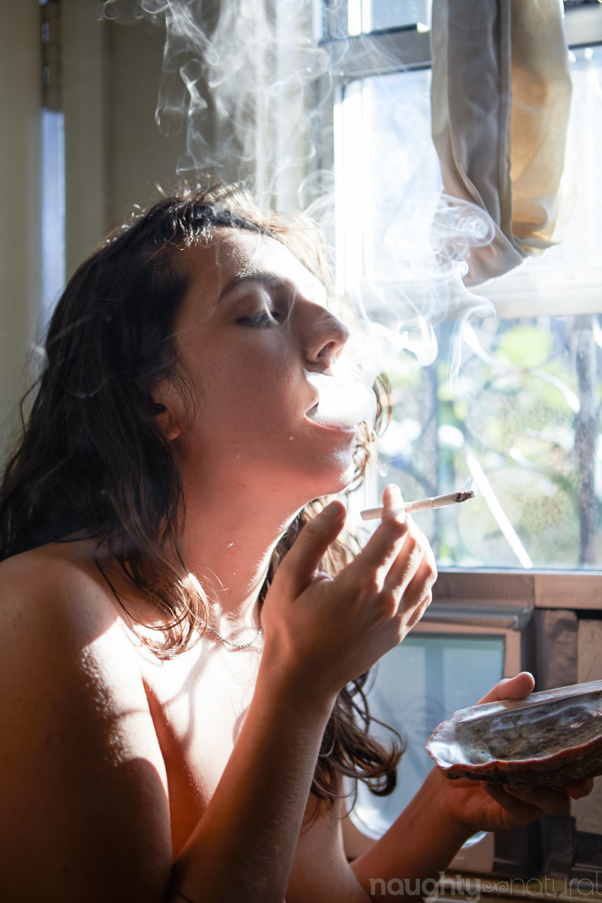 Amateur babe Nikki Silver smokes a spliff while posing naked indoors and out