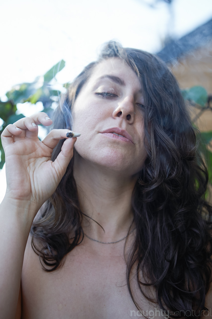 Amateur babe Nikki Silver smokes a spliff while posing naked indoors and out